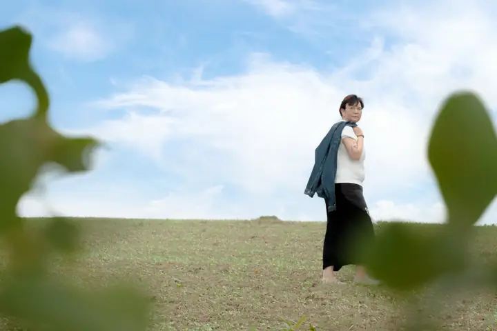 Nicole Dreis barfuß auf dem Feld unter weitem Himmel