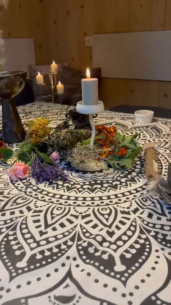 Kerze, Kräuter und Räucherschalen auf dem Mandala-Tischtuch