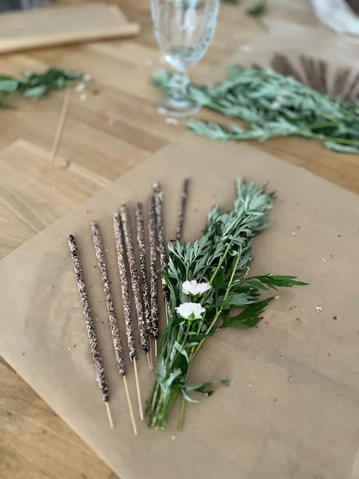 Selbst gemachte Räucherstäbchen neben einem Kräuterbund