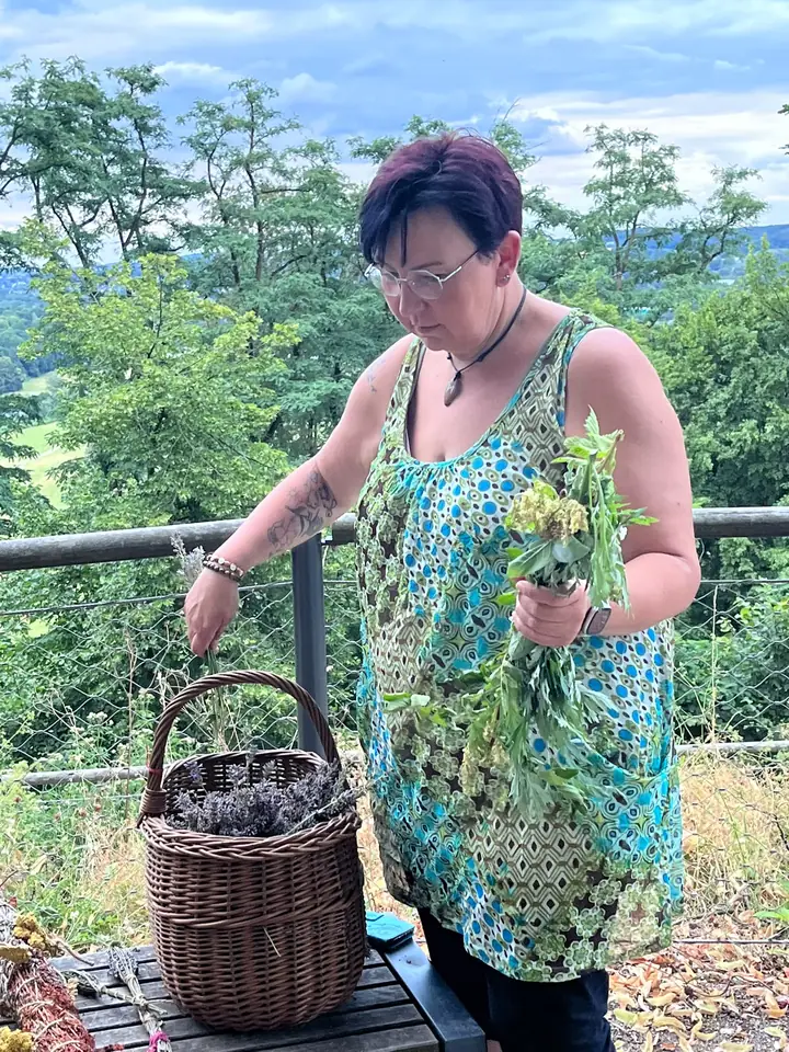 Nicole Dreis sammelt Kräuter in einen Weidenkorb