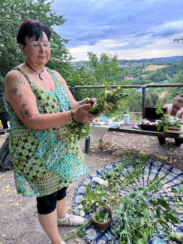 Nicole Dreis bindet draußen ein Kräuterbündel